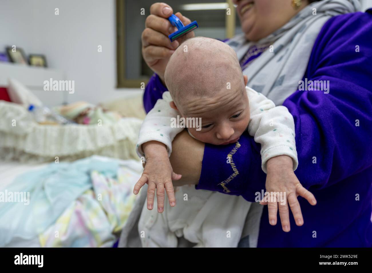 bambina che si radica i capelli con un rasoio affilato. rasatura dei capelli per 1 mese Foto Stock