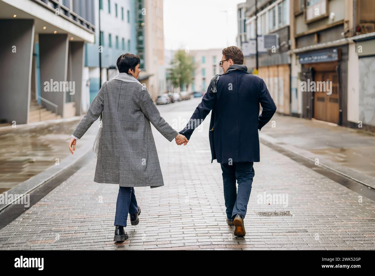 Bell'uomo e bella donna che si abbracciano a vicenda mentre camminano per la città, divertendosi, fotografando lo stile di vita Foto Stock