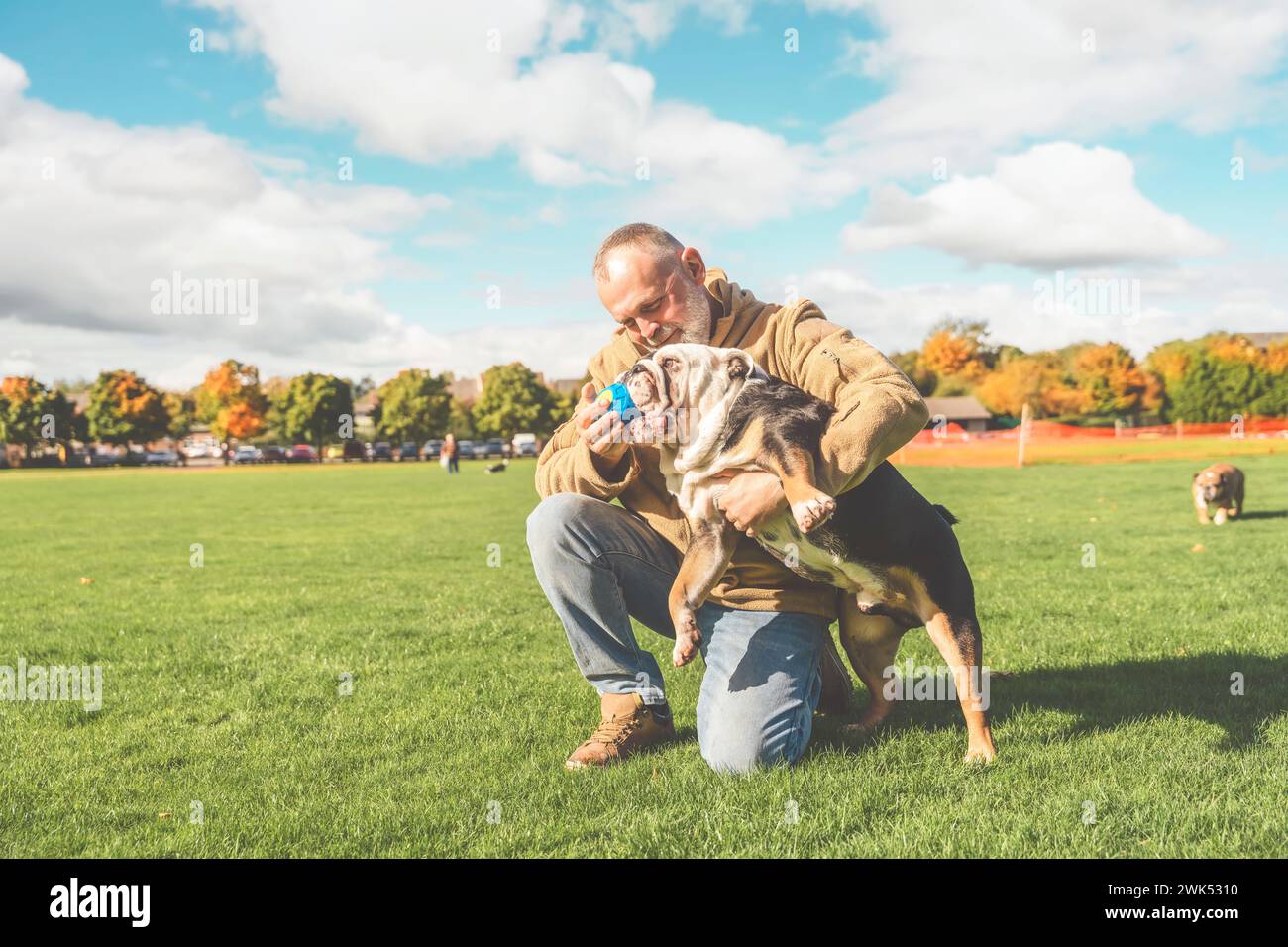 Un vecchio che gioca con il suo cane nel parco Foto Stock