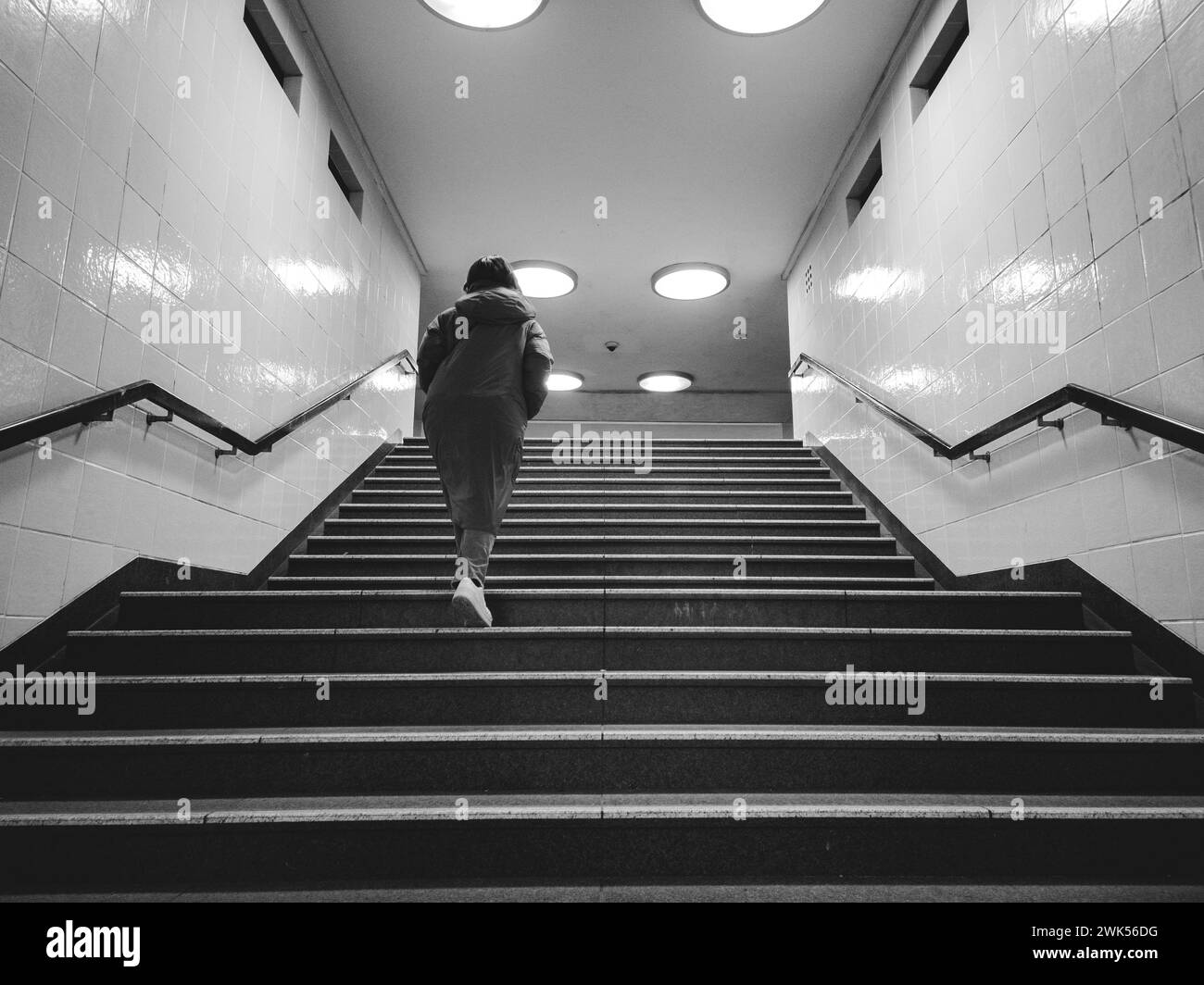 Persona che cammina lungo la scalinata in una metropolitana a Berlino Foto Stock