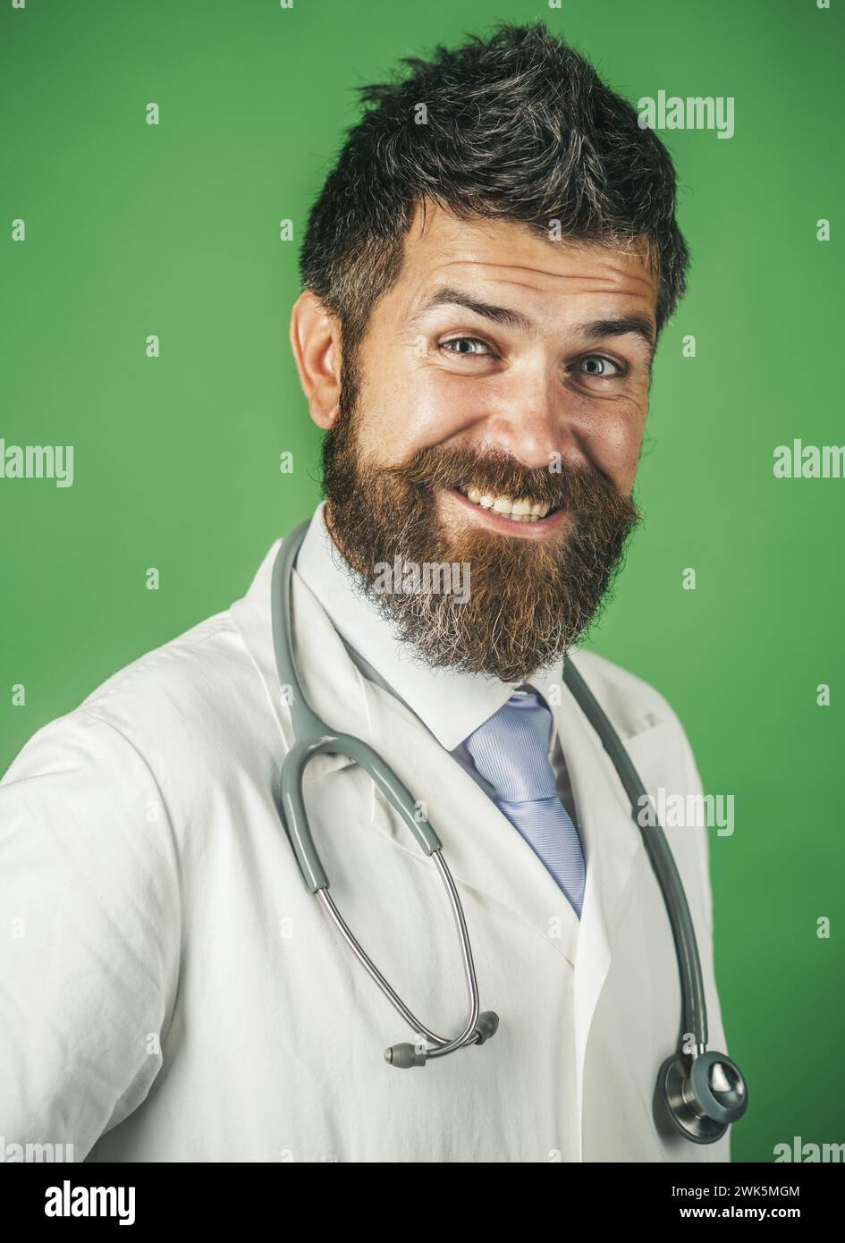 Felice maschio medico in bianco cappotto medico con stetoscopio. Servizi di trattamento, assistenza sanitaria, medicina e ambulanza. Uomo barbuto in uniforme da medico con Foto Stock