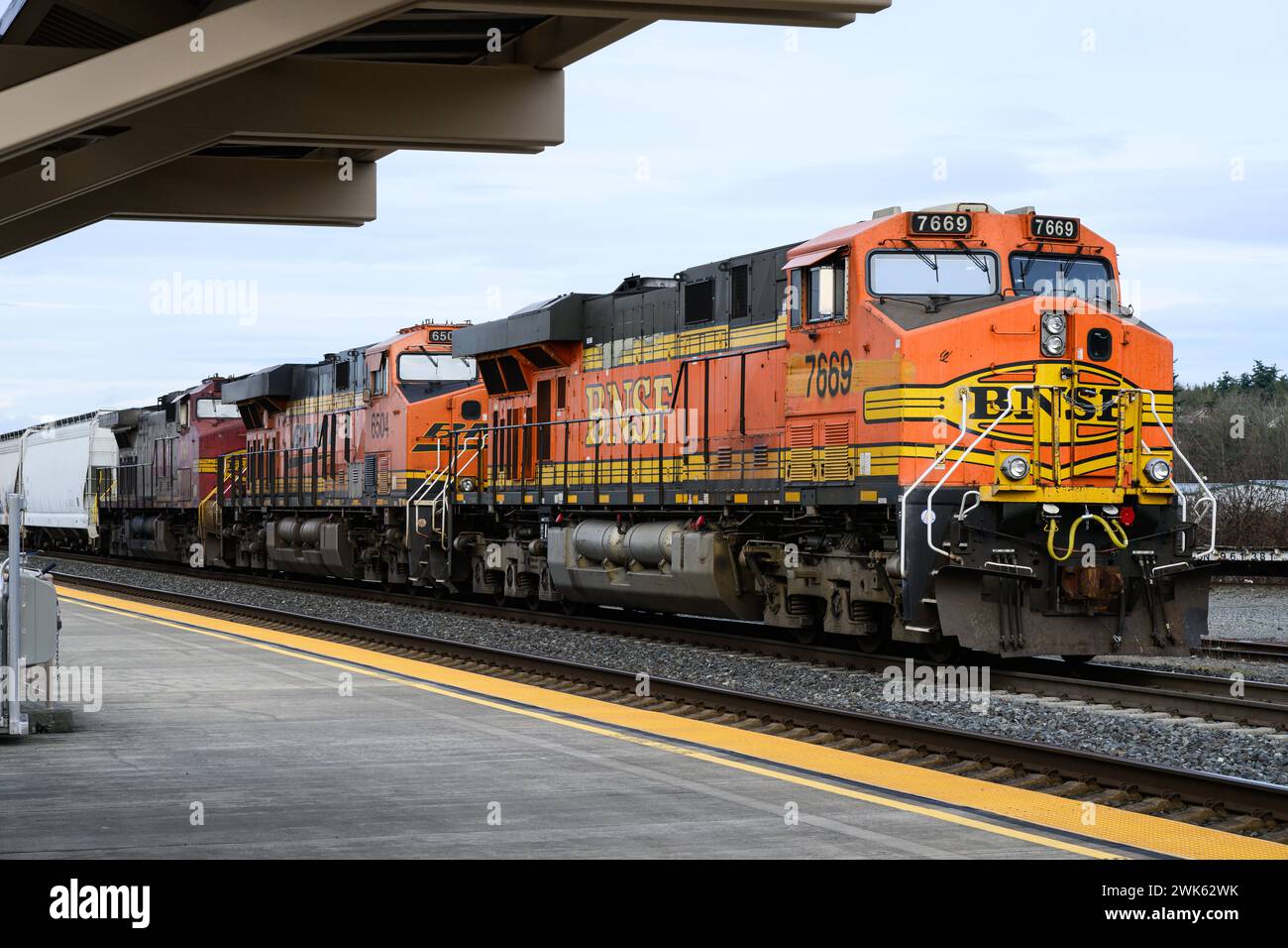 Stanwood, WA, USA - 2 febbraio 2024; treno merci BNSF presso la stazione ferroviaria di Stanwood con tre motori Foto Stock