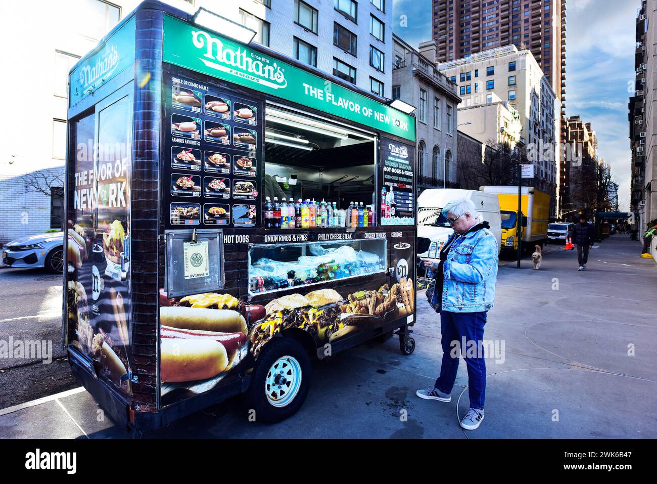 Donna in piedi di fronte a un camion Nathans Hot Dog Food a New York Foto Stock