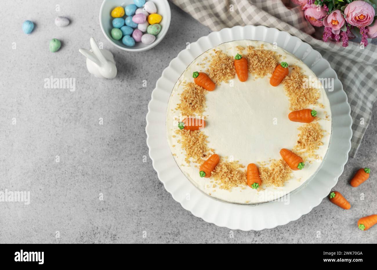 Torta di carote pasquali fatta in casa con noci, ghiacciata con formaggio spalmabile. Dolce dolce. Piatto con deliziosa torta di carote Foto Stock