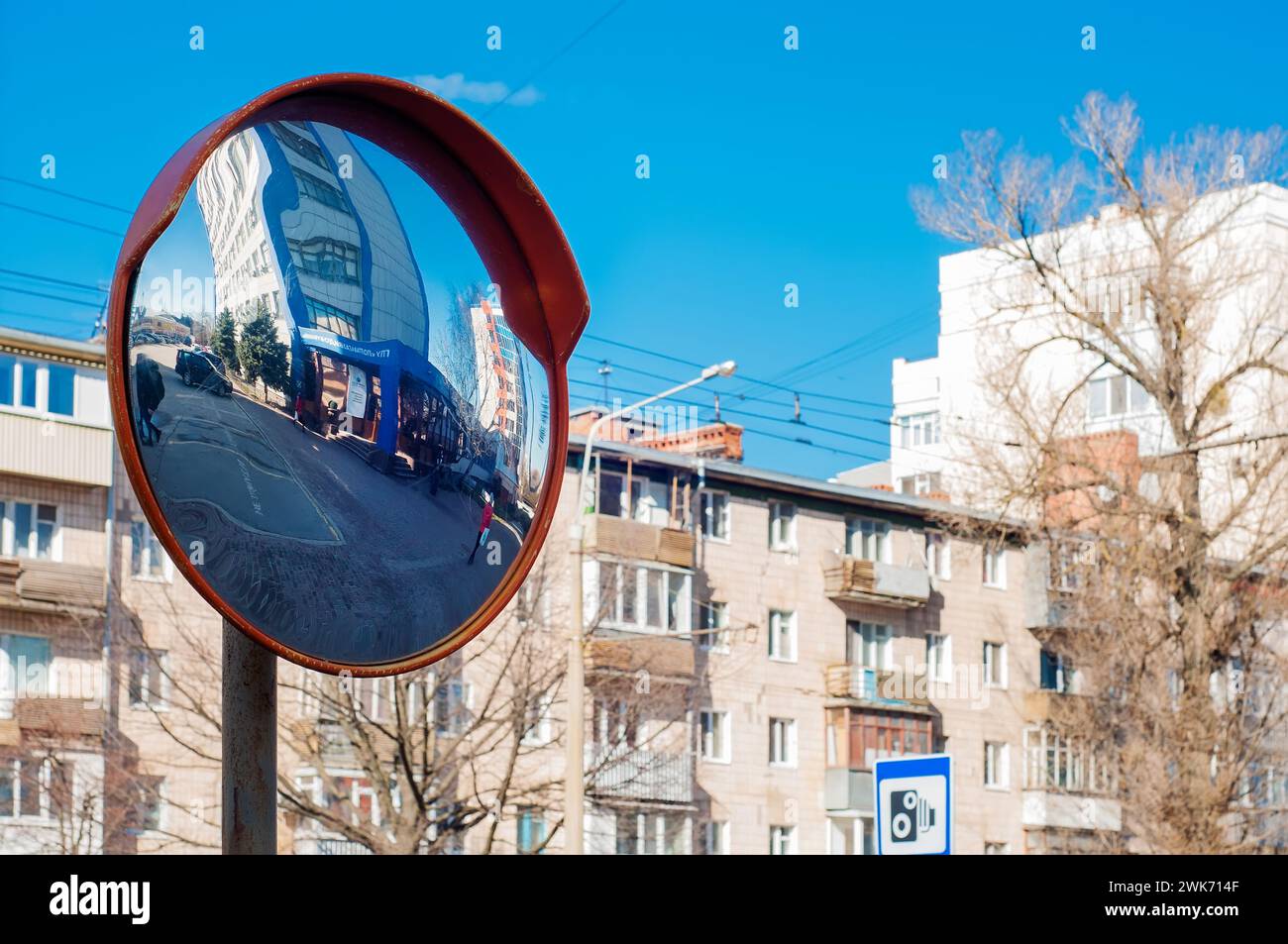 Specchio rotondo su un palo per migliorare la visibilità della strada, intersezione pericolosa. Specchio sferico su una strada cittadina Foto Stock