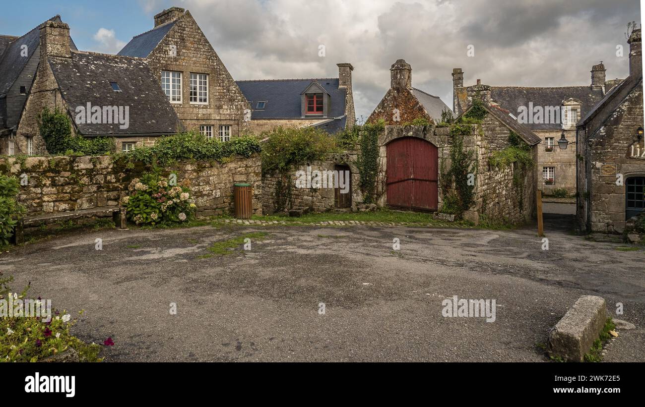 Vista delle tradizionali case in pietra sotto un cielo nuvoloso in un vecchio villaggio di Locronan Bretagne Foto Stock