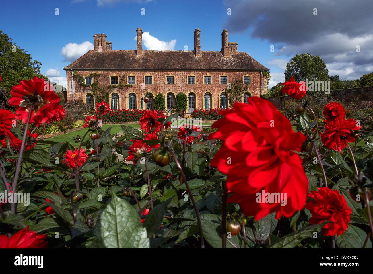 Strode House Barrington Court vicino a Ilminster Somerset Inghilterra Regno Unito con Lily Pond Garden e Red Dahlias in estate Foto Stock