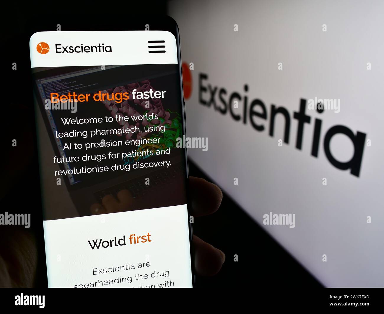 Persona che detiene lo smartphone con pagina web della società britannica di intelligenza artificiale Exscientia plc con logo. Messa a fuoco al centro del display del telefono. Foto Stock