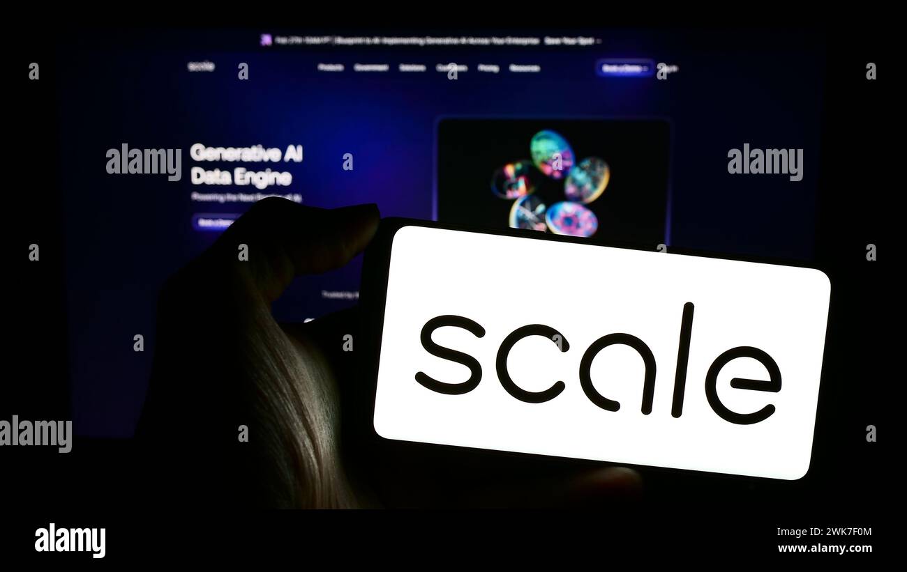 Persona che possiede un telefono cellulare con il logo della società americana di intelligenza artificiale Scale ai Inc. Di fronte alla pagina Web. Mettere a fuoco il display del telefono. Foto Stock