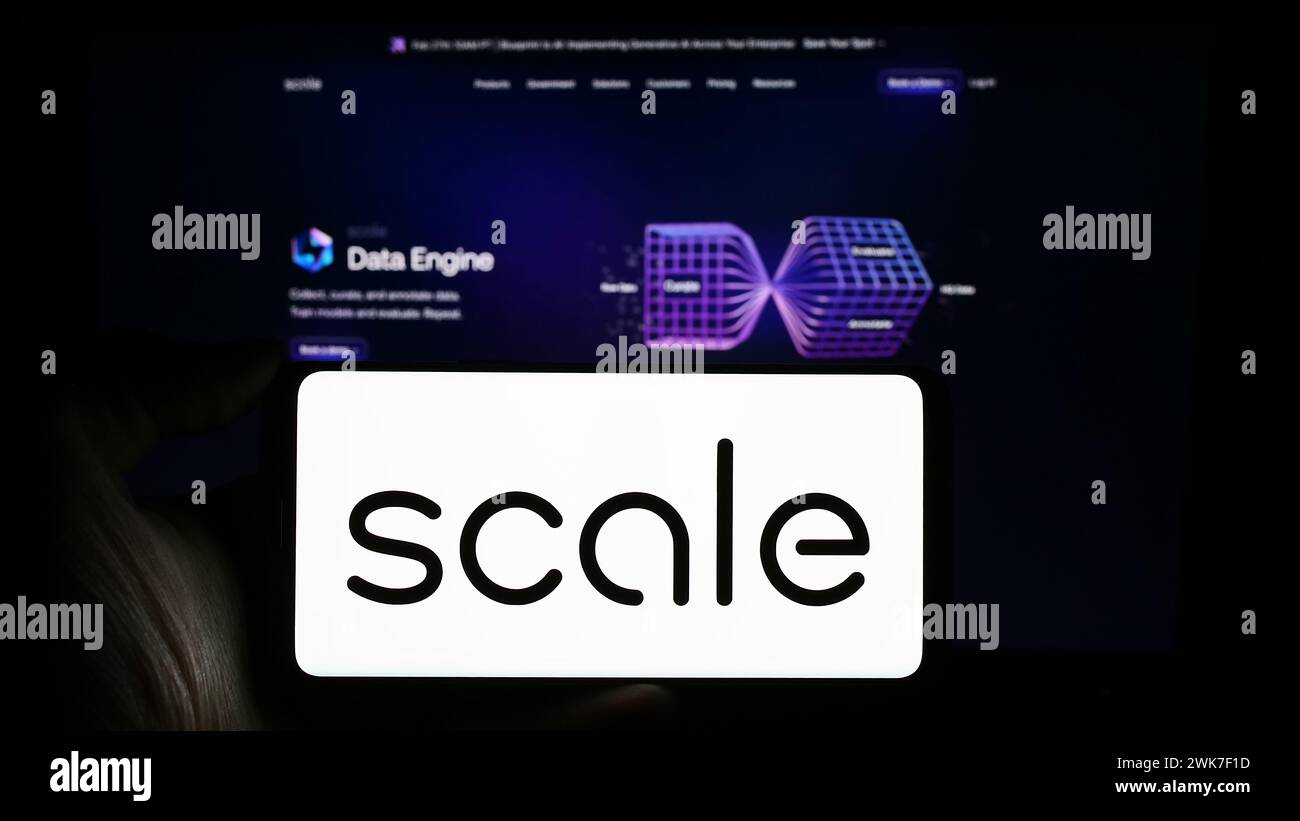 Persona che detiene un cellulare con il logo della società statunitense di intelligenza artificiale Scale ai Inc. Di fronte alla pagina Web aziendale. Mettere a fuoco il display del telefono. Foto Stock