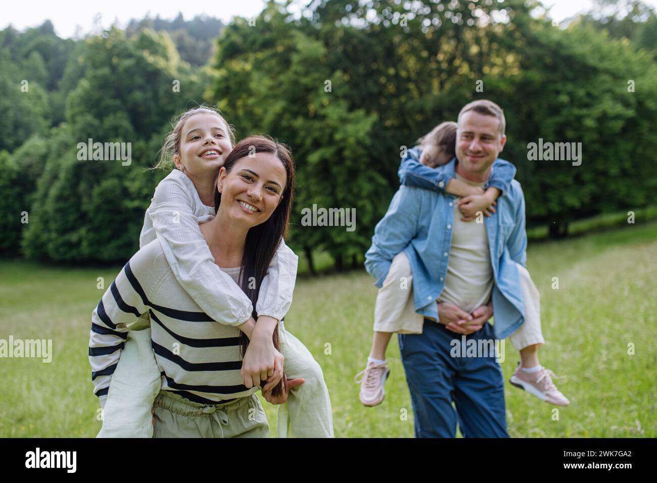 Ritratto di una bella famiglia, genitori che fanno il coro di due figlie, divertendosi nella natura. Foto Stock