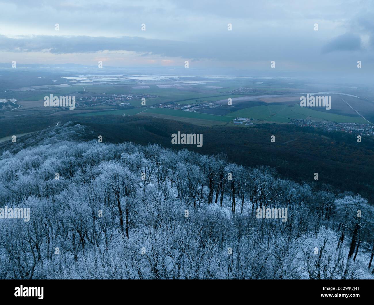 Vista aerea della foresta invernale con ghiaccio o gelo. Congelamento sulle colline. Vista su un paesaggio innevato. Foto Stock