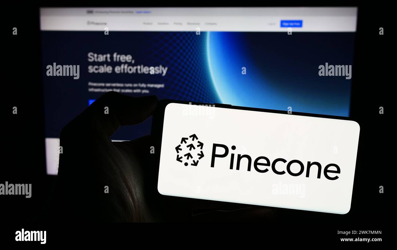 Persona che possiede un telefono cellulare con il logo della società statunitense di intelligenza artificiale Pinecone Systems Inc. Davanti alla pagina Web. Mettere a fuoco il display del telefono. Foto Stock