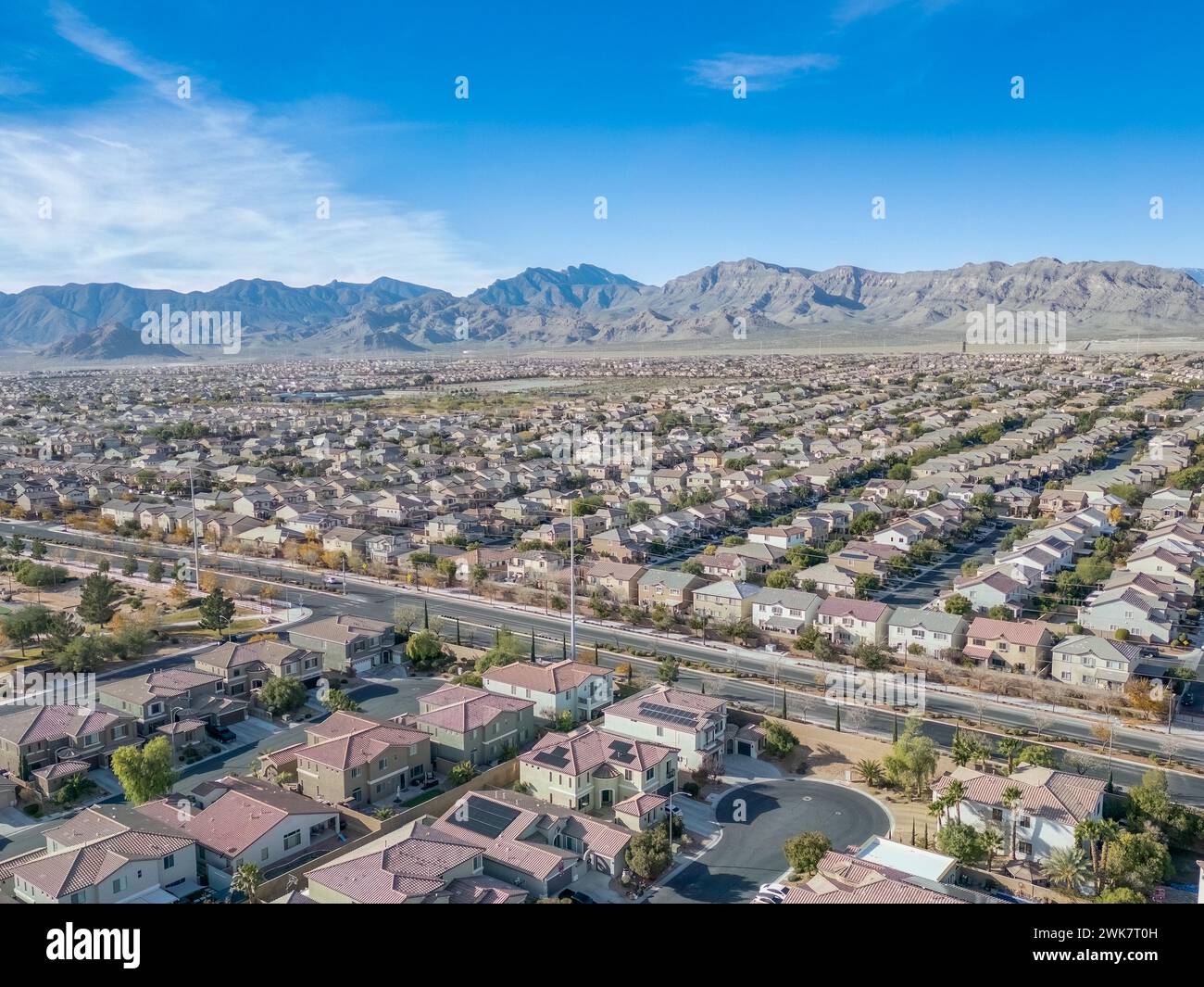 Una vista aerea di un quartiere di Las Vegas con case uniformi, spazi verdi e sfondo di montagna Foto Stock