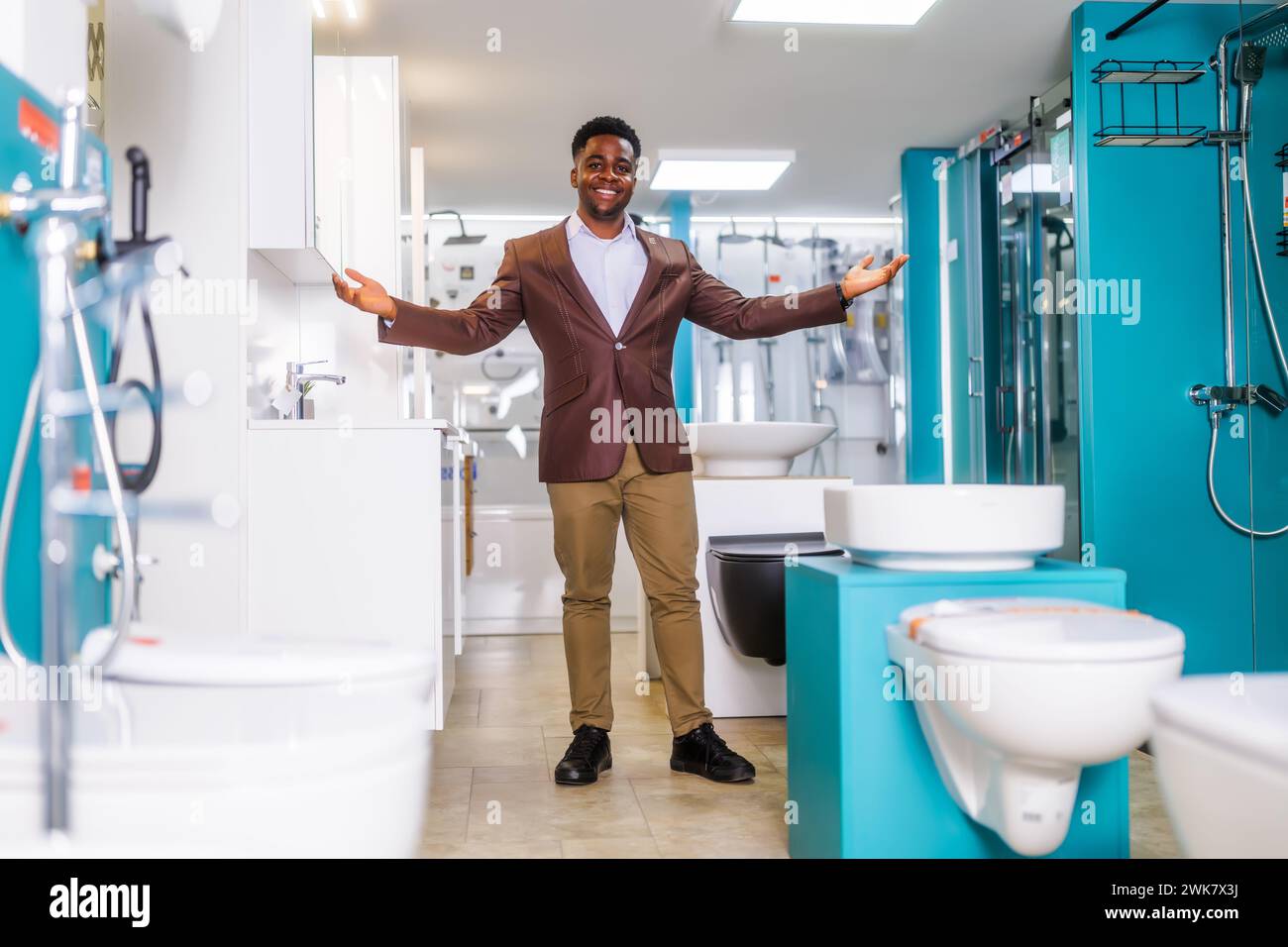 Ritratto del venditore nel negozio di articoli da bagno. L'uomo felice lavora in un negozio di bagni. Occupazione delle vendite. Foto Stock