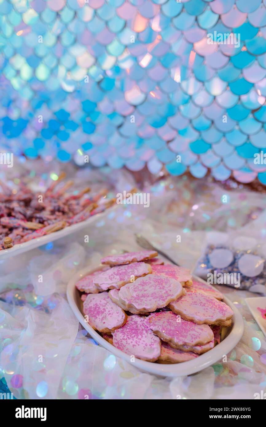 Il rosa cosparge di biscotti ghiacciati rosa con fondo scala blu Foto Stock