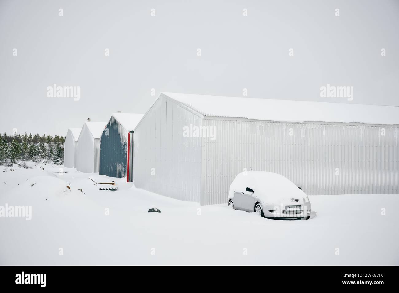 Moderni magazzini e auto coperte di neve durante l'inverno Foto Stock