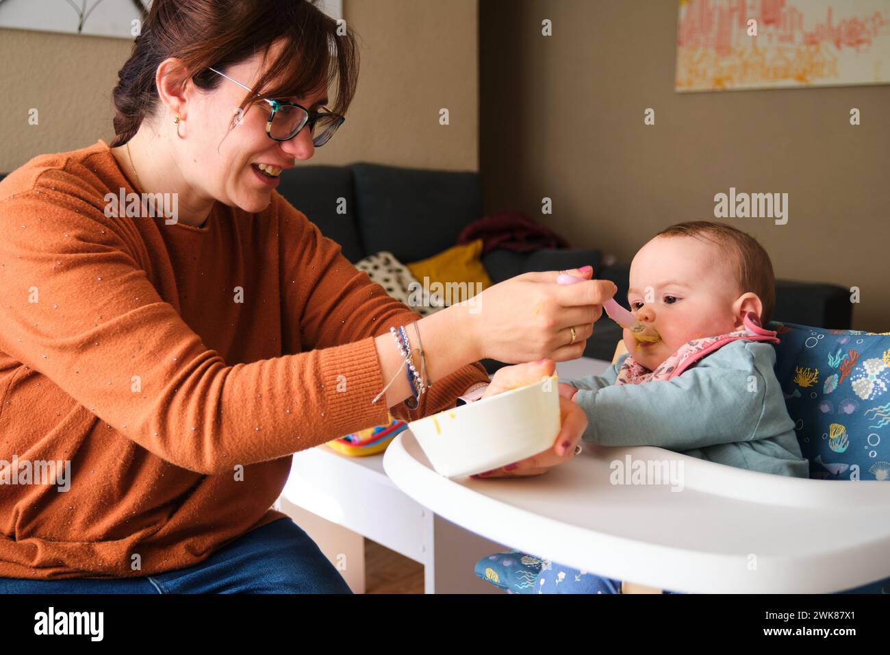 La madre dà da mangiare alla bambina di 6 mesi con purè di verdure. Foto Stock