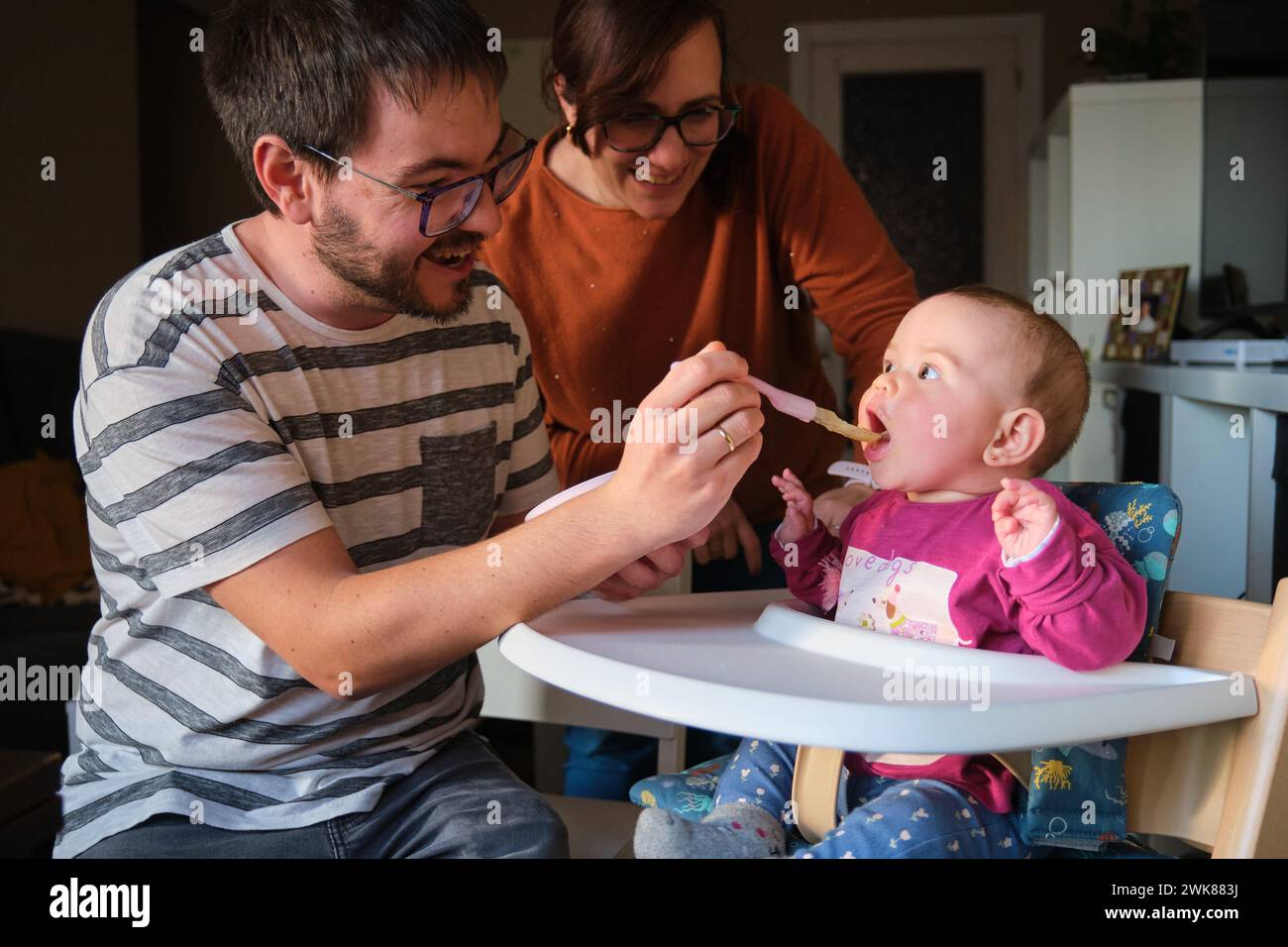 I genitori nutrono la bambina di 6 mesi con purè di verdure. Foto Stock