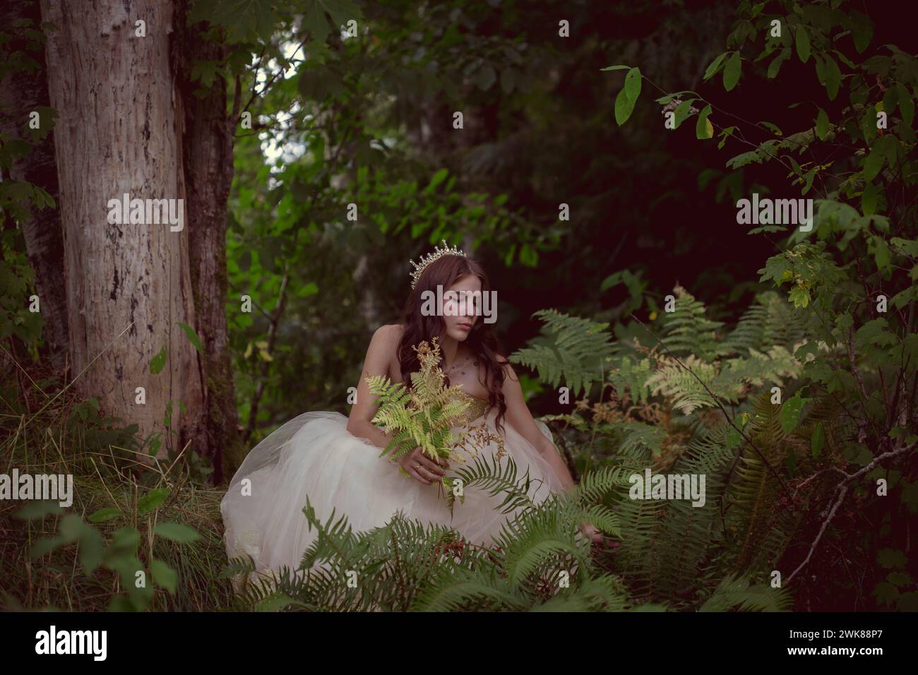 Principessa nella foresta che raccoglie felci Foto Stock