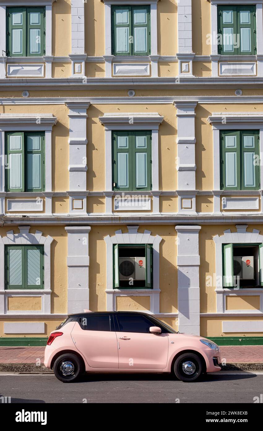 Il palazzo del XIX secolo. Ospita il Ministero della difesa tailandese a Bangkok, Thailandia, con una serie simmetrica di finestre e un'auto rosa parcheggiata davanti Foto Stock