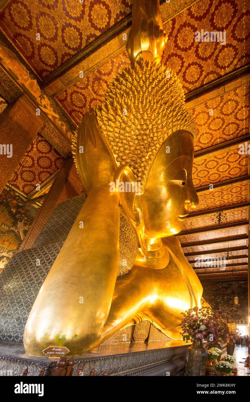 La gigantesca statua di Buddha sdraiato, dorata con foglia d'oro, nel tempio Wat Pho a Bangkok, Thailandia. Foto Stock