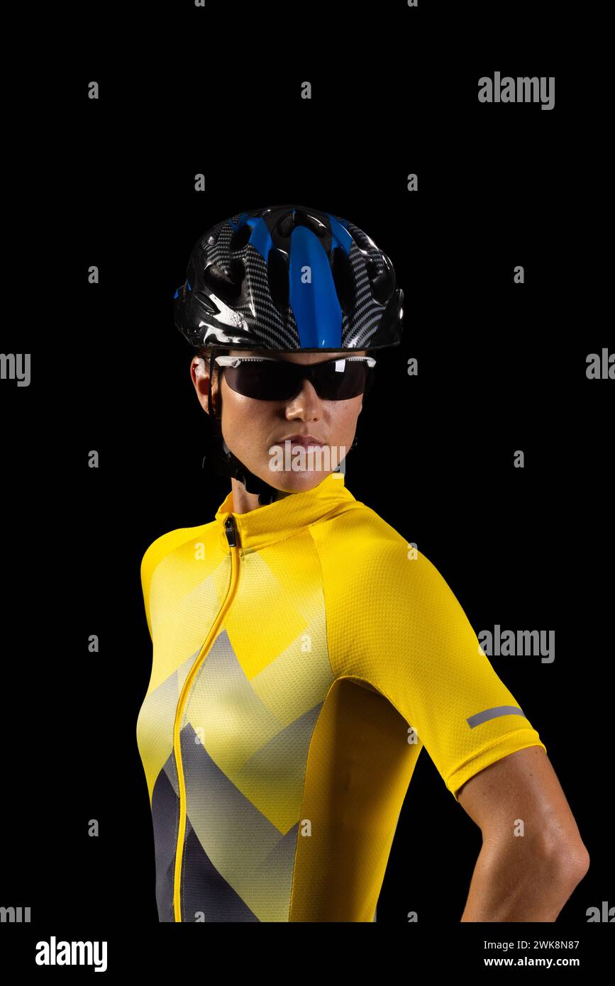 La giovane ciclista caucasica vestita con l'attrezzatura da ciclismo si pone con fiducia Foto Stock