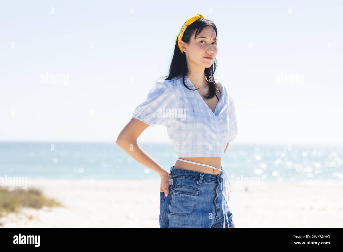 La giovane donna birazziale sta in piedi con sicurezza sulla spiaggia, con spazio di copia inalterato Foto Stock