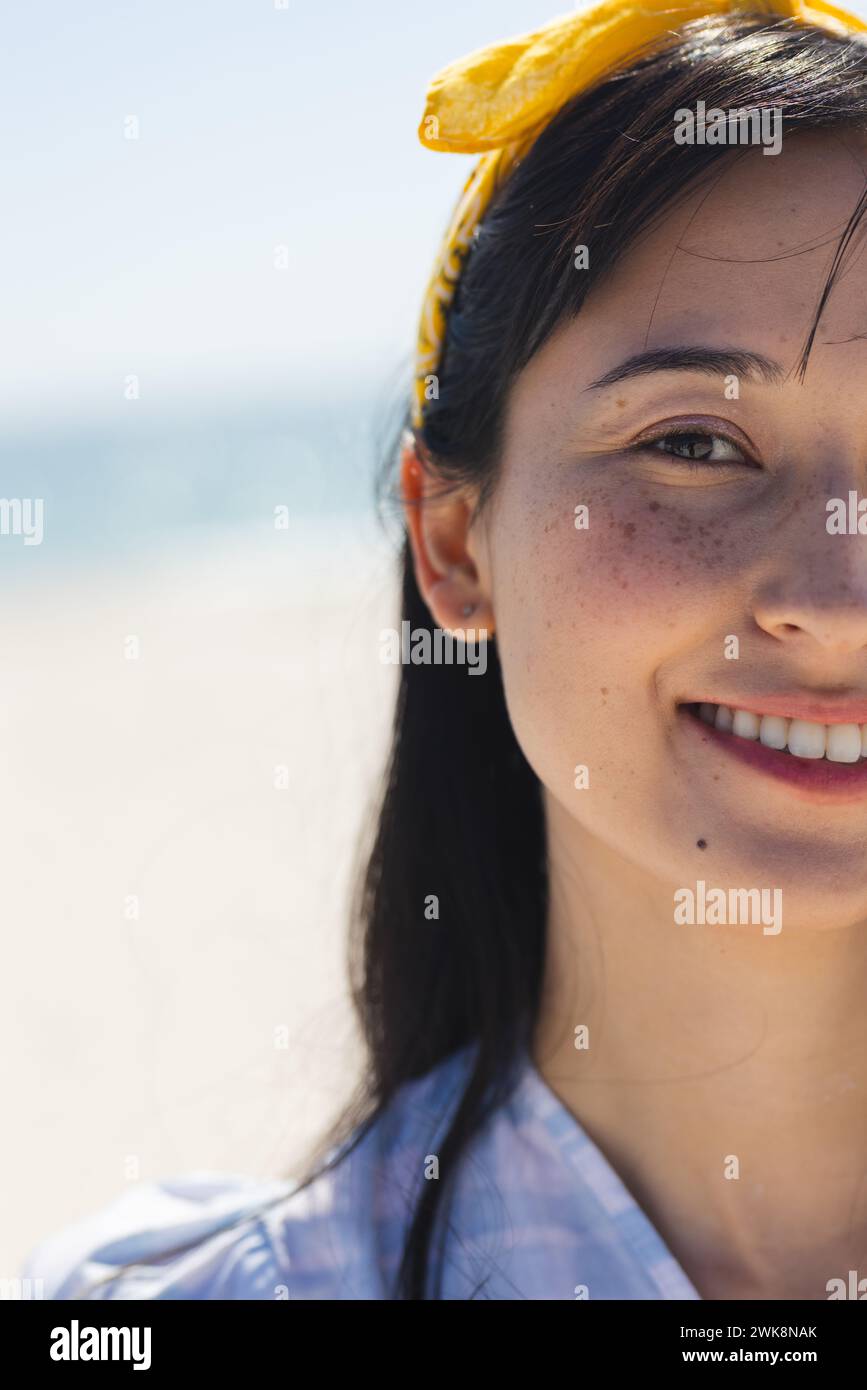 La giovane donna birazziale sorride brillantemente in spiaggia, con spazio di copia Foto Stock