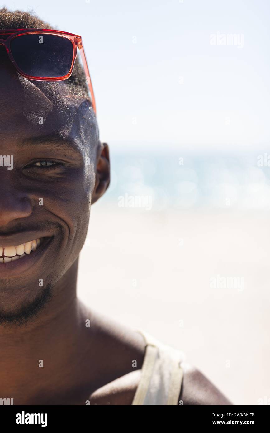 Il giovane afroamericano sorride in spiaggia, con spazio di copia inalterato Foto Stock