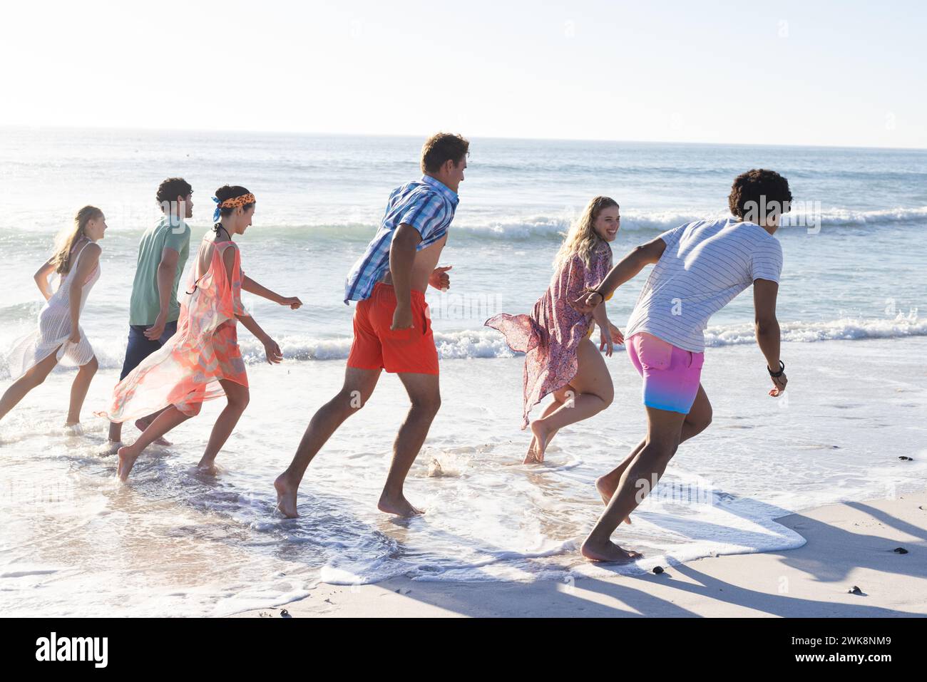 Gruppi diversi di amici trascorrono una giornata in spiaggia insieme Foto Stock