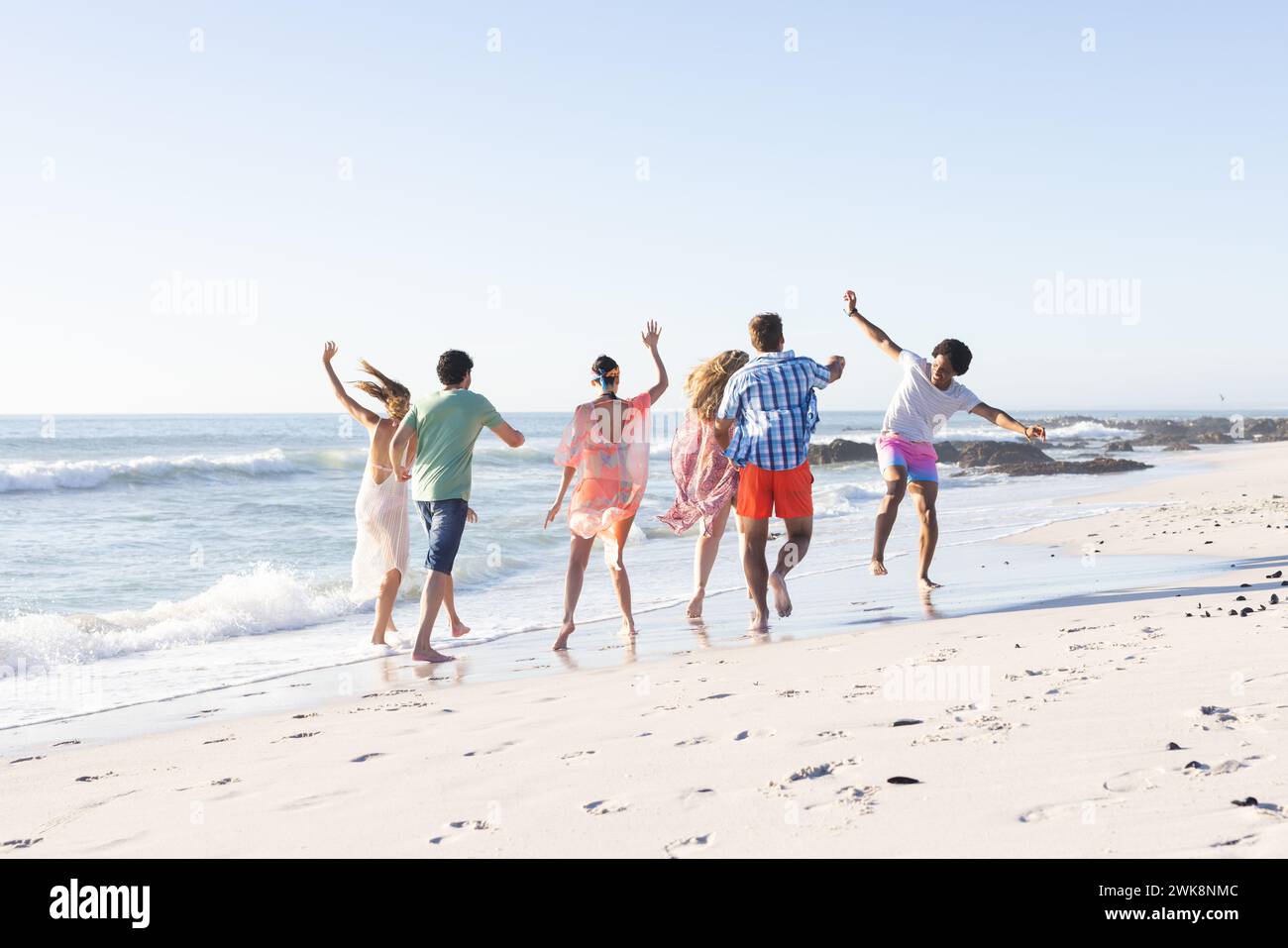 Gruppi diversi di amici trascorrono una giornata in spiaggia, con spazio per le copie Foto Stock