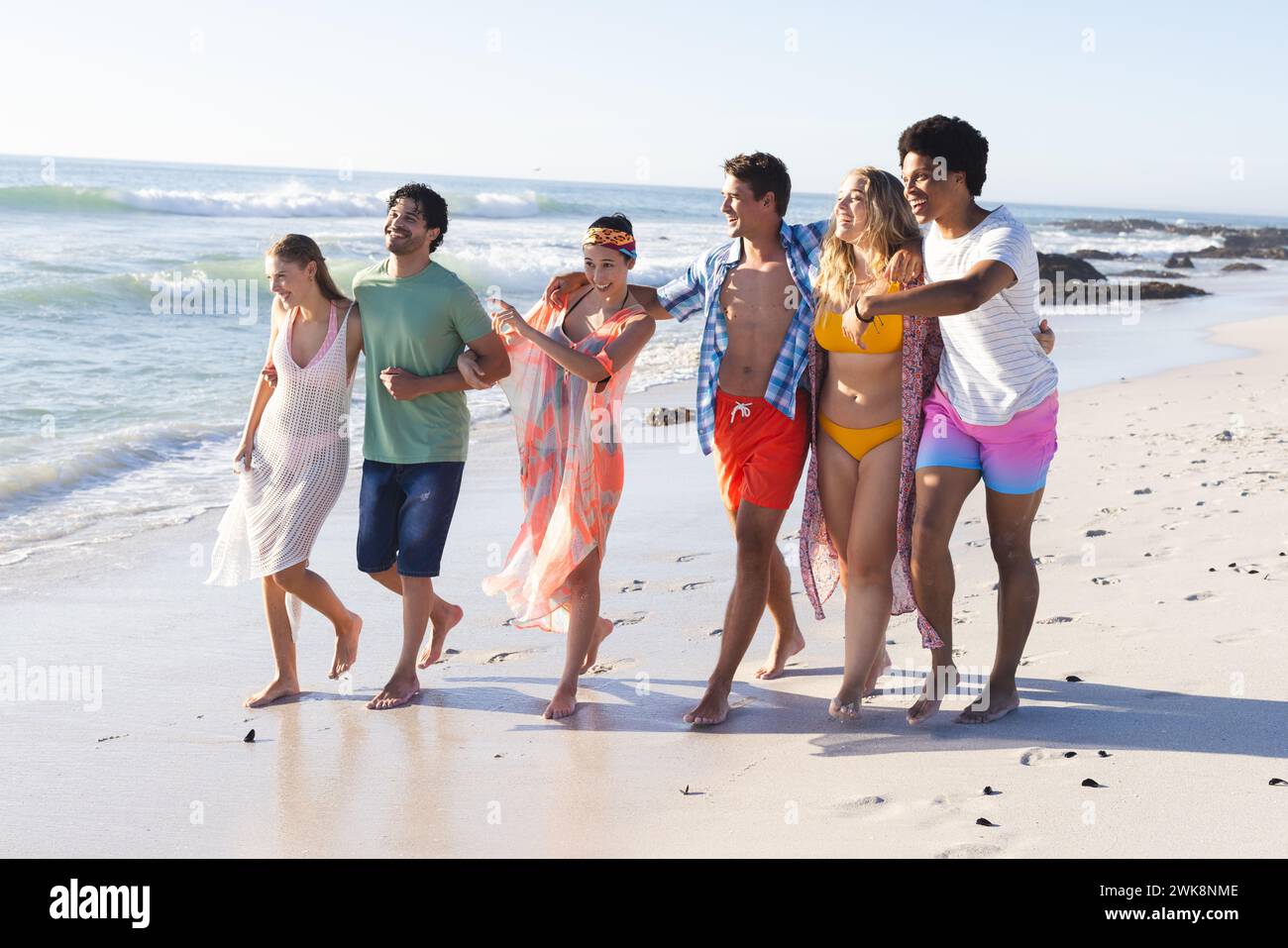 Gruppi diversi di amici trascorrono una giornata in spiaggia insieme Foto Stock