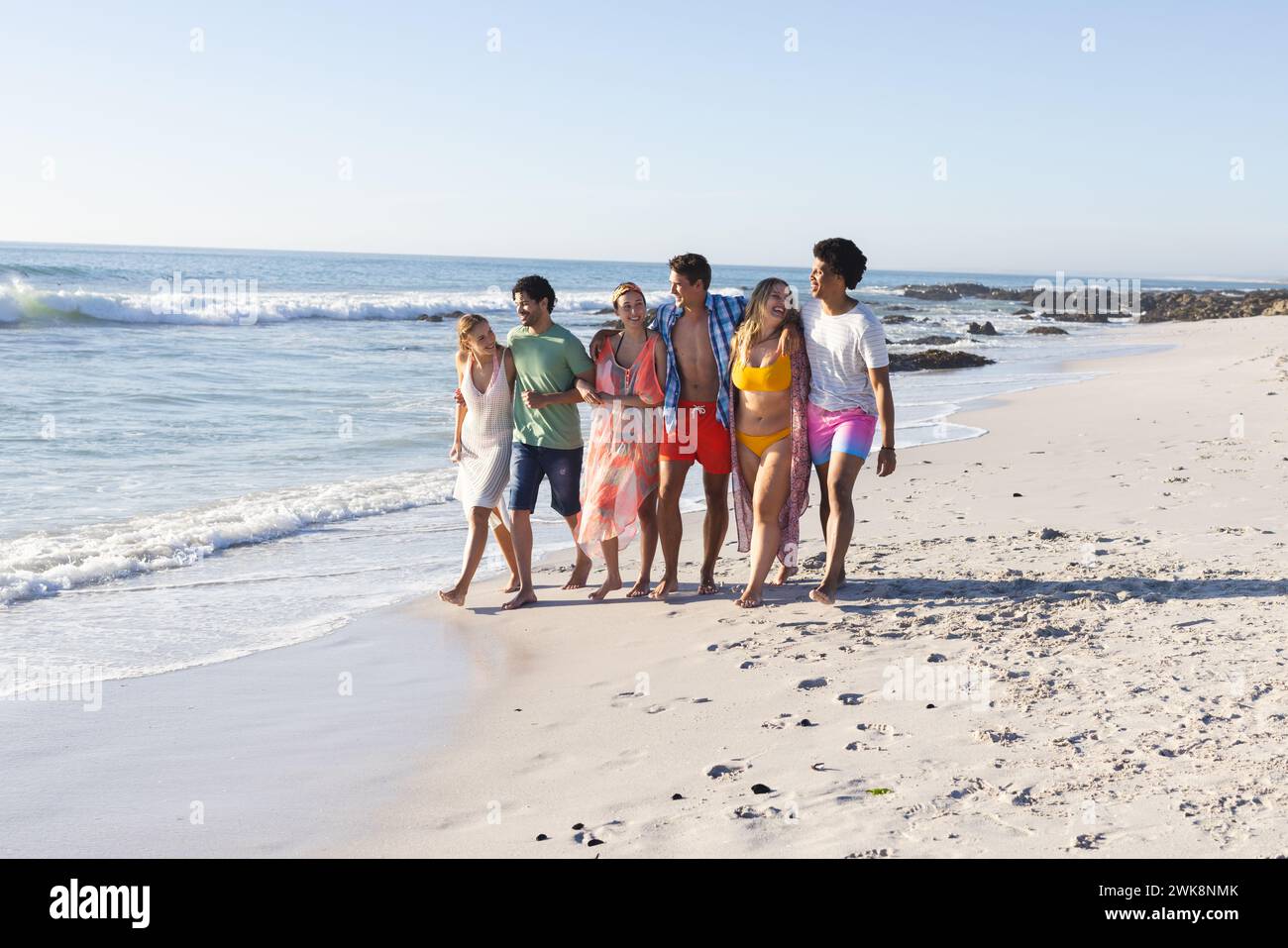Gruppi diversi di amici trascorrono una giornata in spiaggia, con spazio per le copie Foto Stock