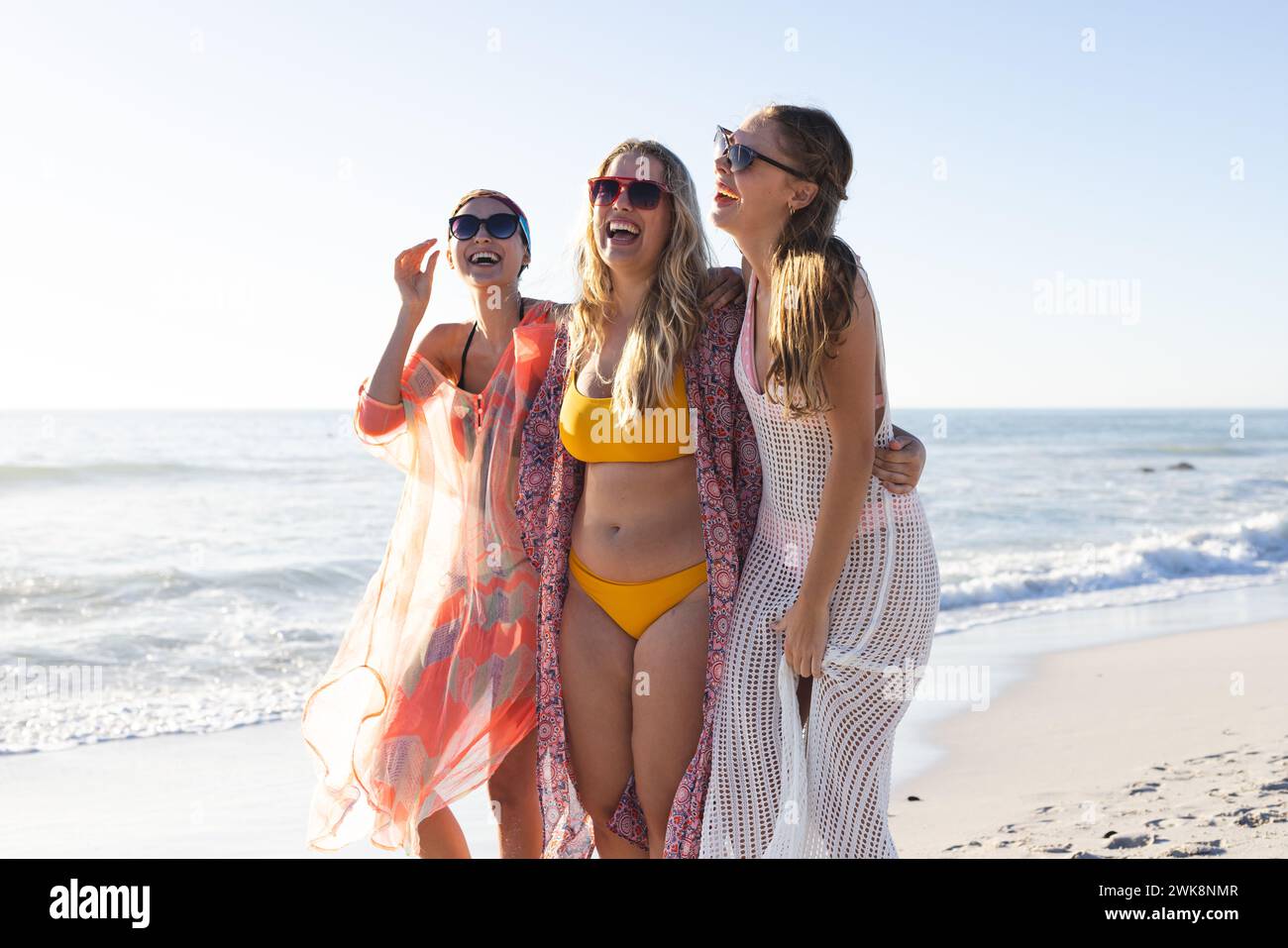 Tre giovani donne si godono una giornata di sole sulla spiaggia Foto Stock