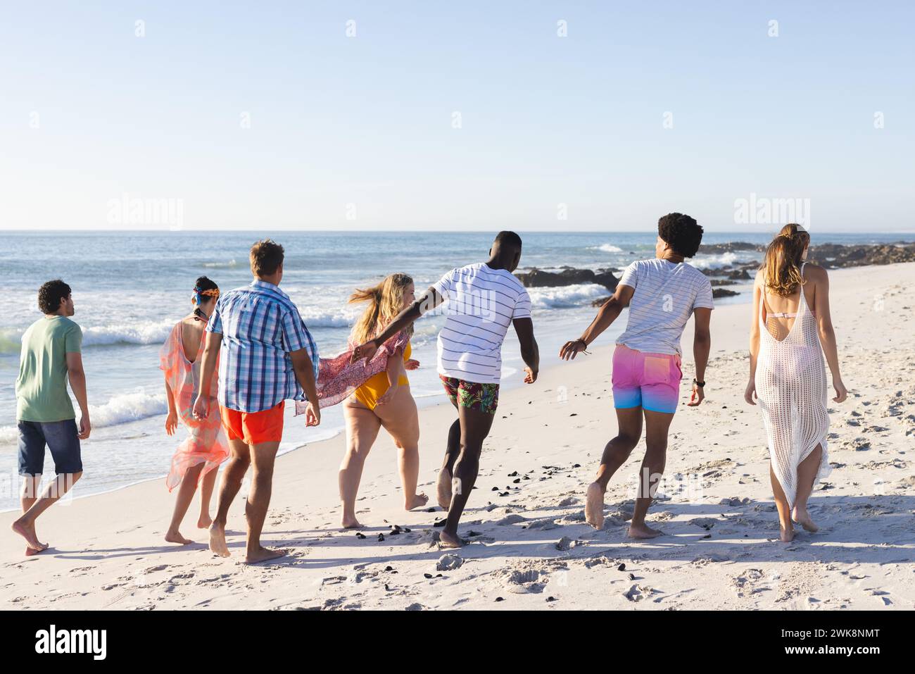 Un gruppo di amici si diverte a fare una passeggiata sulla spiaggia Foto Stock