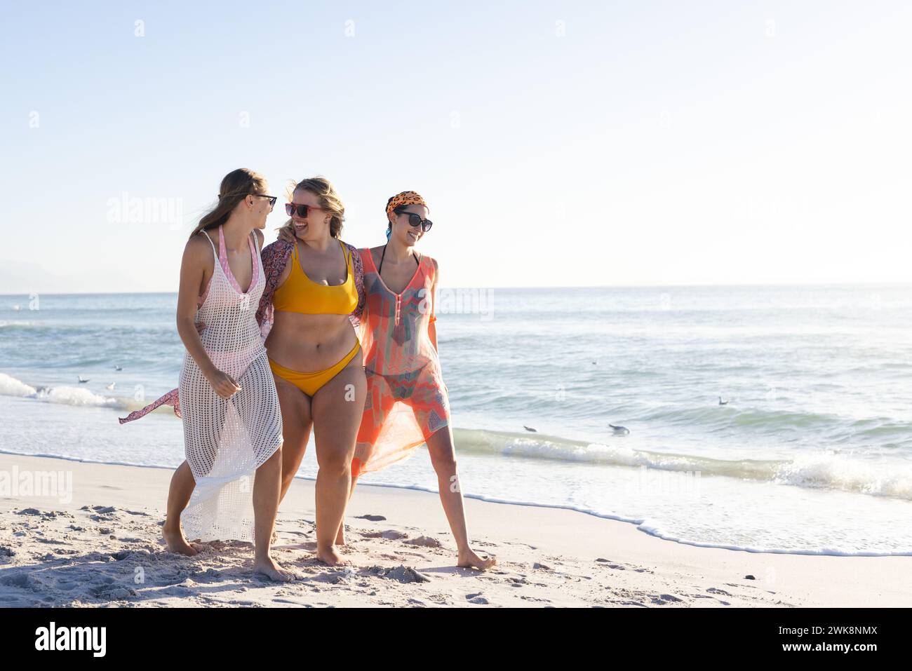 Tre giovani donne si godono una giornata di sole sulla spiaggia, con spazio per le copie Foto Stock