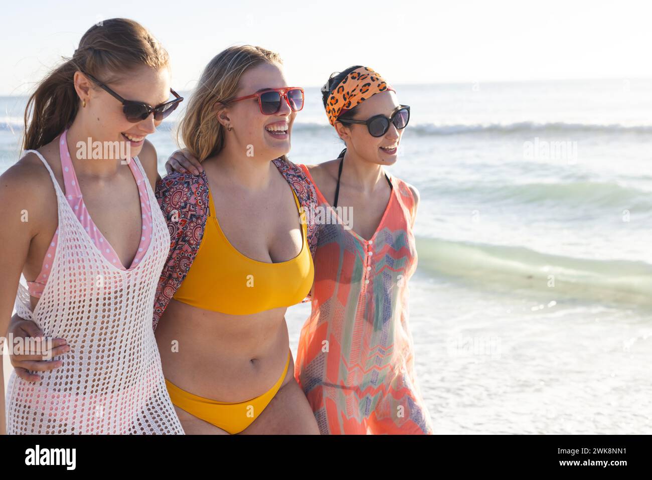 Tre giovani donne caucasiche si godono una giornata di sole sulla spiaggia, con spazio per le copie Foto Stock