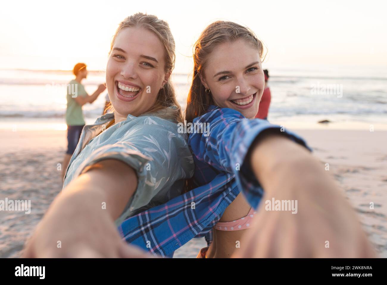 Due giovani donne caucasiche condividono un momento di gioia sulla spiaggia Foto Stock