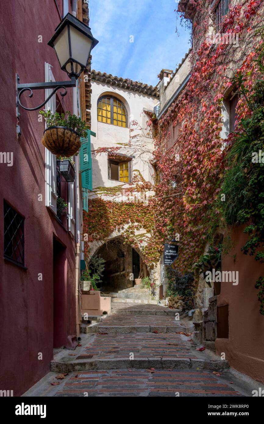 Si affacciano su rustici scalini di mattoni che portano ai tetti della graziosa cittadina di Roquebrune-cap-Martin. Circondato da pareti calde, marroni e in terracotta. Foto Stock