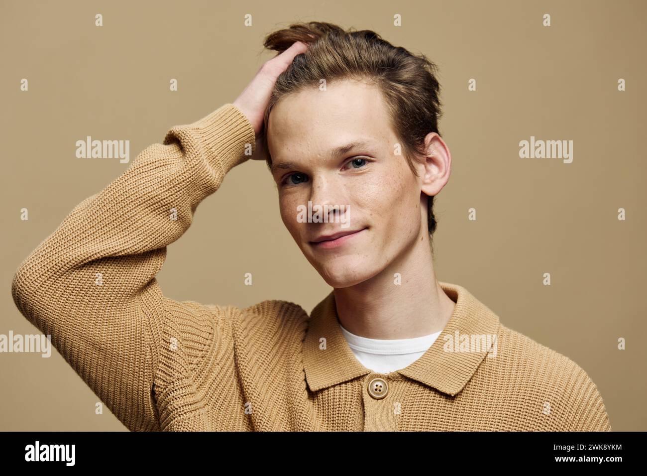 Il giovane attore fiducioso mette in scena una posa elegante contro la parete Blue Studio Foto Stock