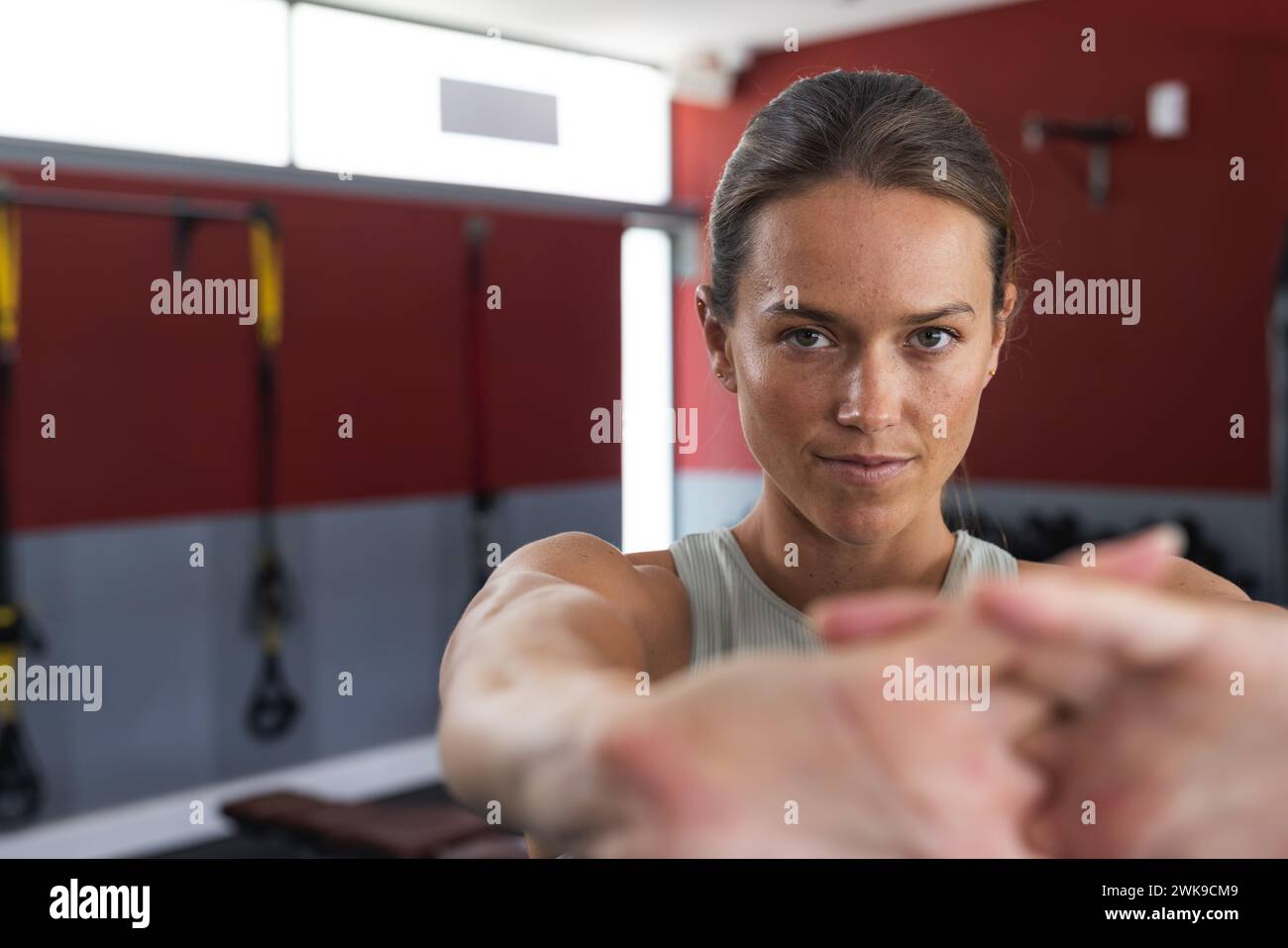 Fit giovane donna caucasica si concentra sul suo allenamento in palestra Foto Stock
