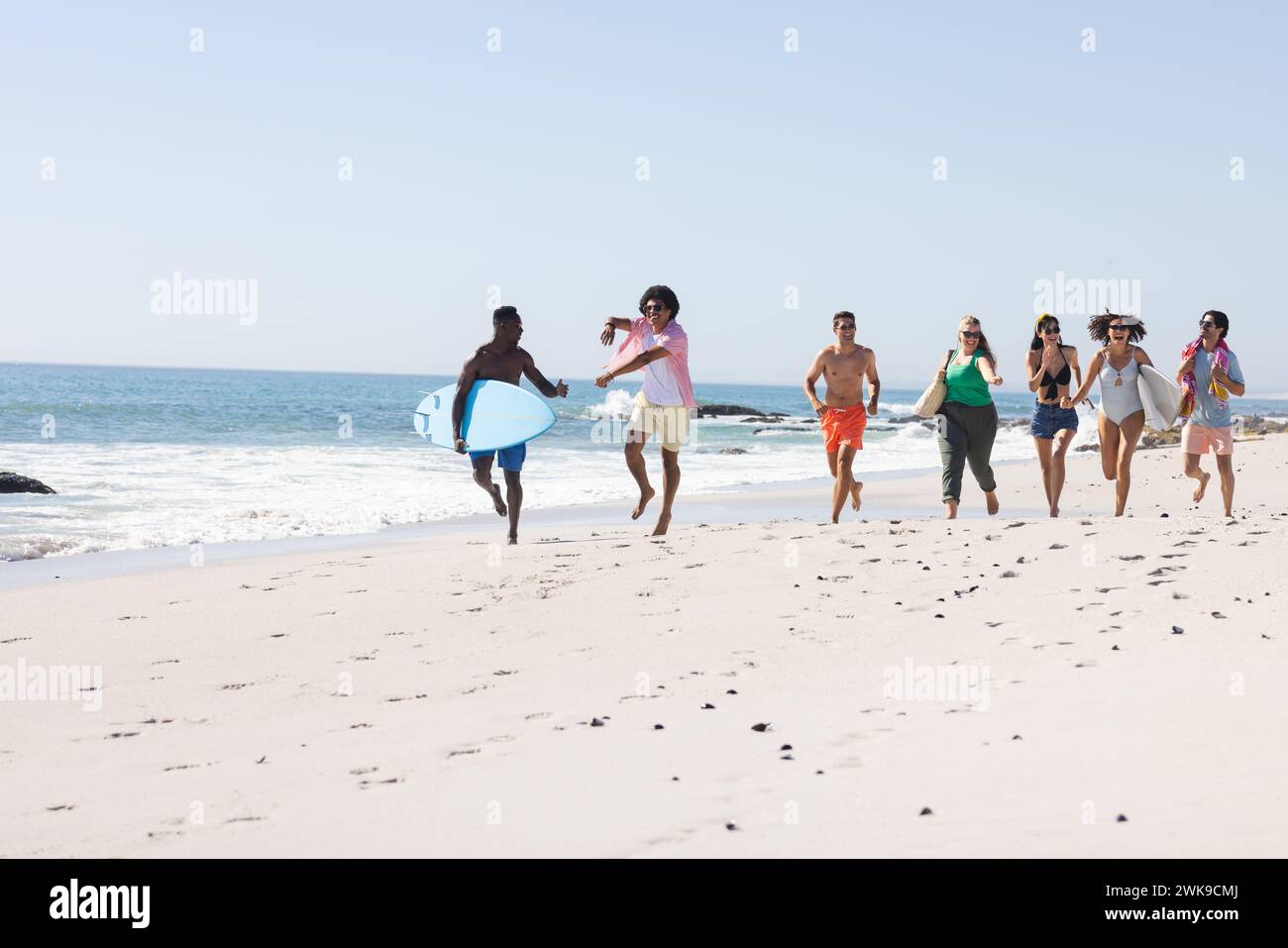 Gruppi diversi di amici trascorrono una giornata in spiaggia con spazio per fotocopie Foto Stock