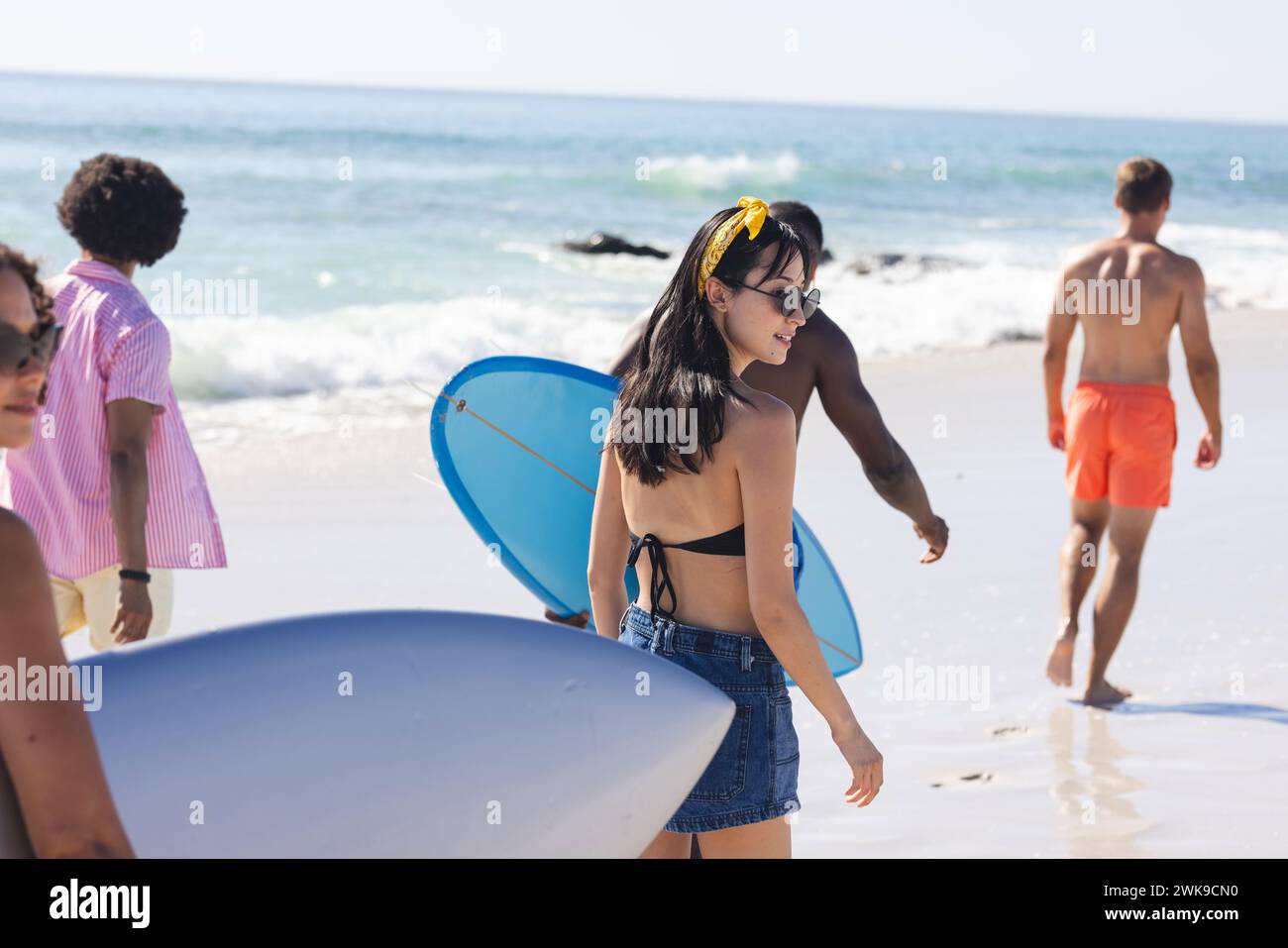 Un gruppo eterogeneo di amici ama una giornata di sole sulla spiaggia Foto Stock