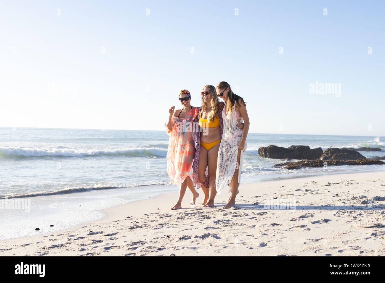 Tre giovani donne si godono una giornata di sole sulla spiaggia, con spazio per le copie Foto Stock