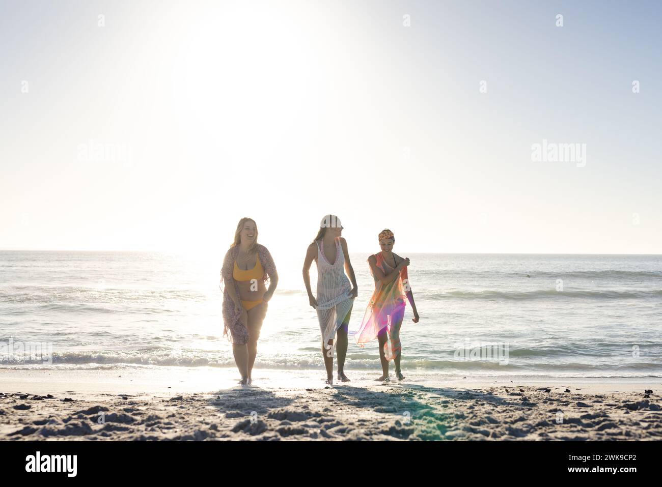 Tre giovani donne si godono una giornata di sole in spiaggia Foto Stock
