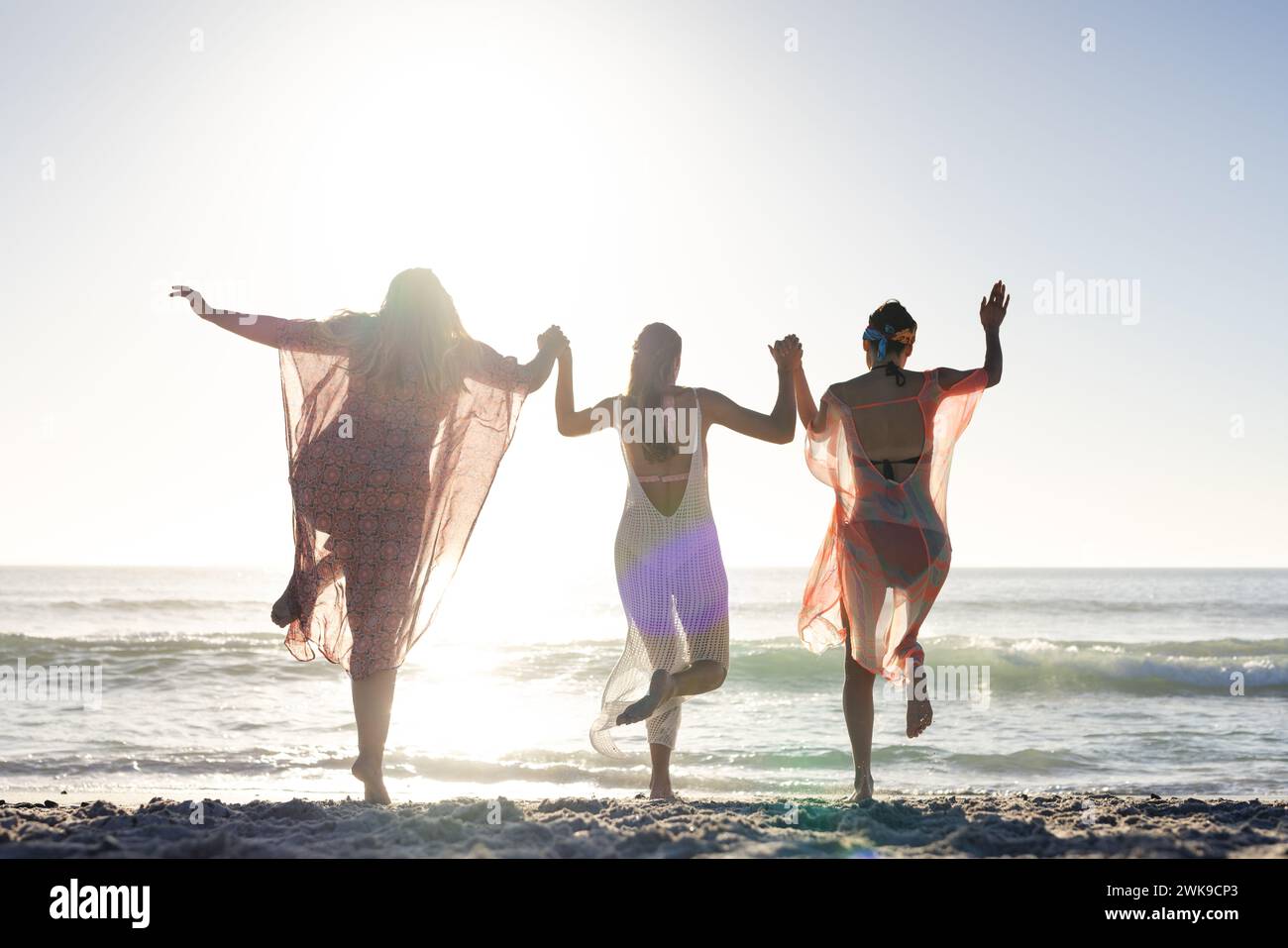 Tre donne si godono una giornata di sole sulla spiaggia Foto Stock