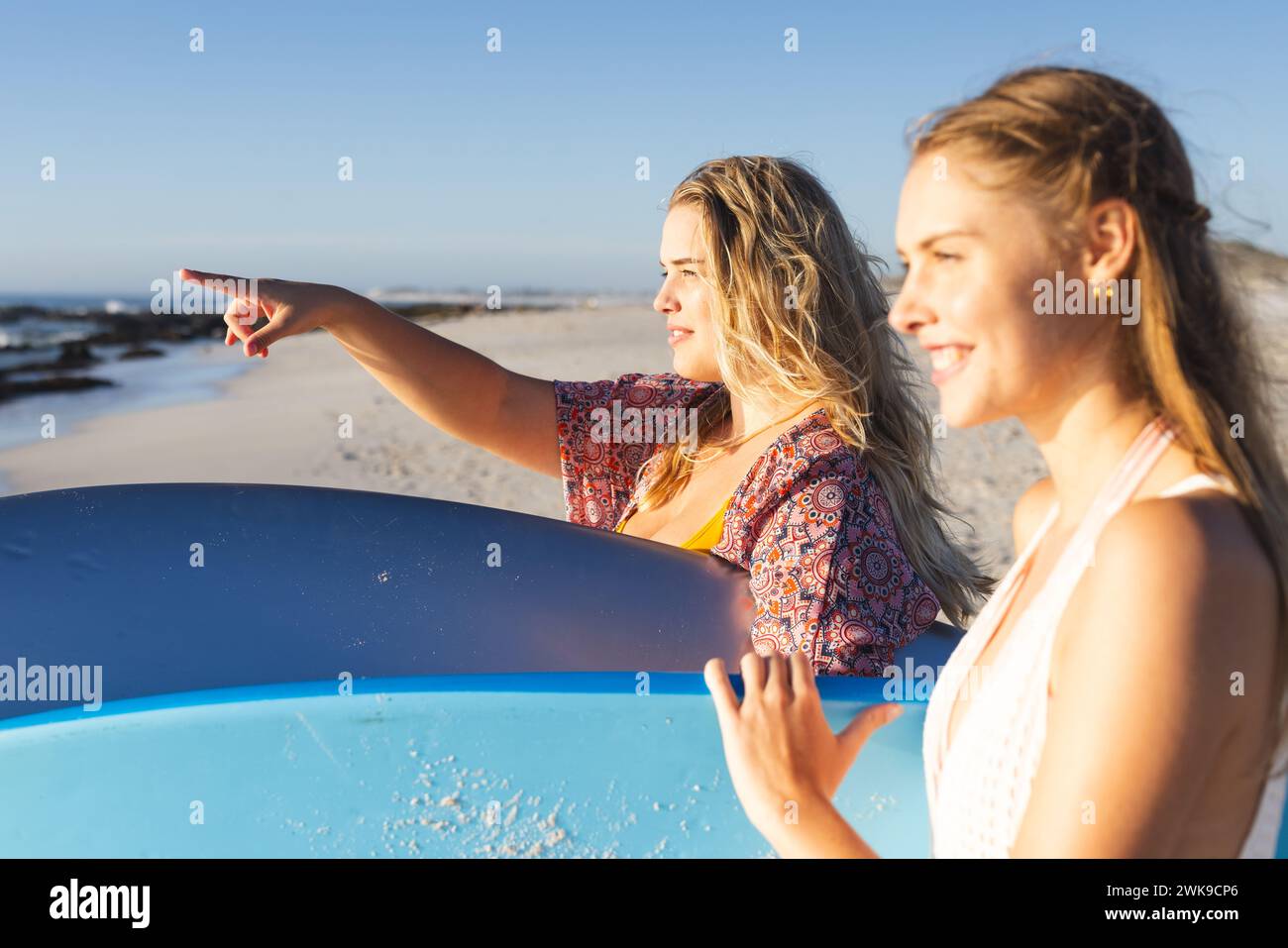 Due giovani donne caucasiche si godono una giornata di sole sulla spiaggia, con spazio per le copie Foto Stock
