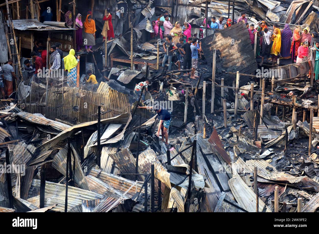 Dacca, Dacca, Bangladesh. 19 febbraio 2024. Un incendio è scoppiato oggi a mezzogiorno nel quartiere Jhilpar di Mirpur, Dacca. Circa 200 case di latta furono completamente bruciate. 8 unità di vigili del fuoco hanno portato l'incendio sotto controllo in un'ora. Gli abitanti delle baraccopoli cercano di trovare i loro ultimi effetti personali dalle baraccopoli bruciate. (Immagine di credito: © Syed Mahabubul Kader/ZUMA Press Wire) SOLO PER USO EDITORIALE! Non per USO commerciale! Crediti: ZUMA Press, Inc./Alamy Live News Foto Stock