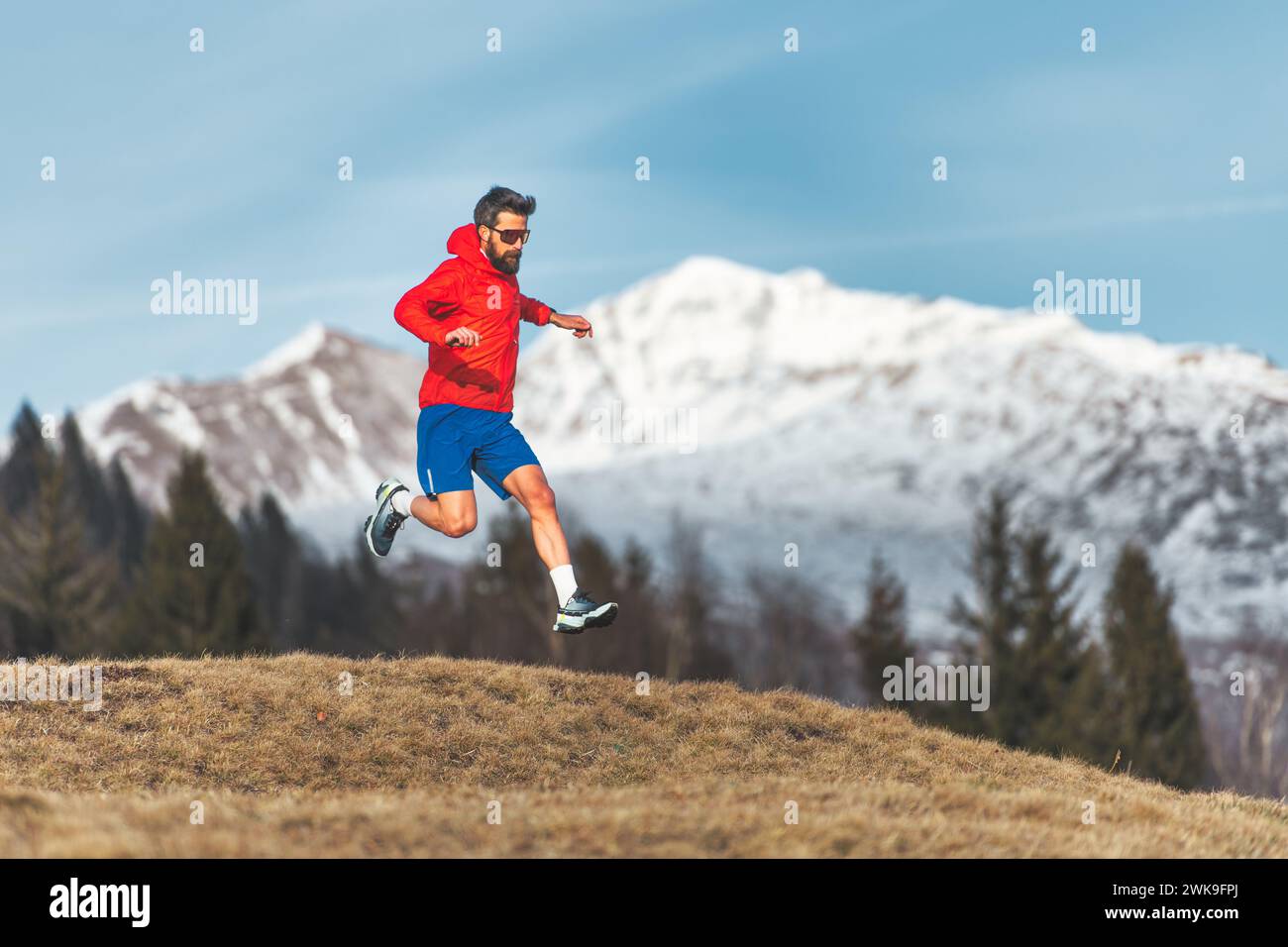 Uomo in azione durante una corsa in montagna sulle alpi italiane Foto Stock